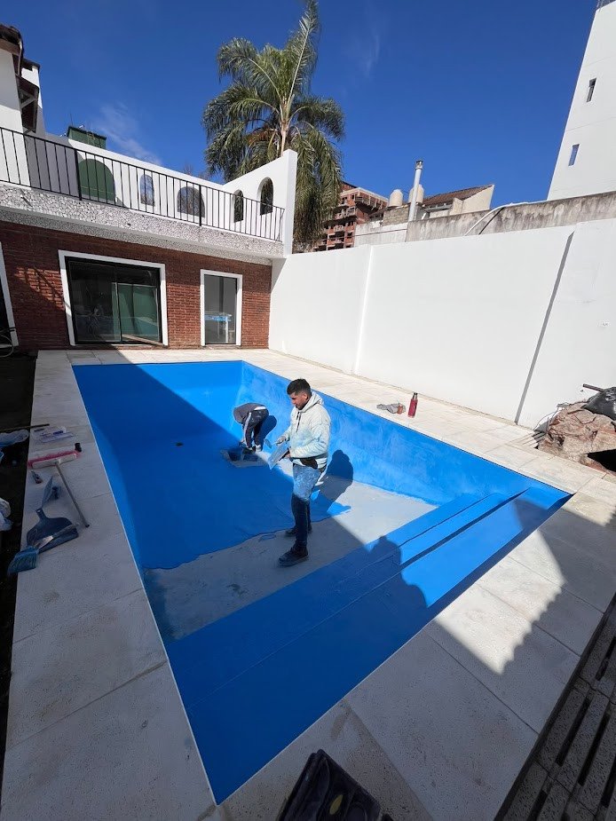 En obra: aplicando el revestimiento azul en la misma pileta